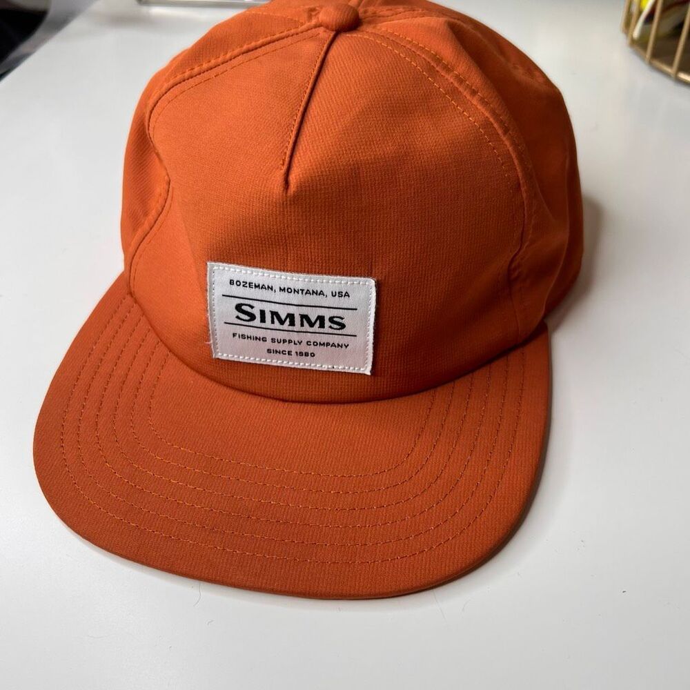 Simms Unstructured Flat Brim Cap in the color Simms burnt Orange